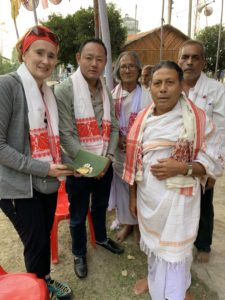 Tshering und werden von einer hinduistischen Gemeinde mit dem weiß-roten Schal begrüßt, der in Assam für ethnische Integration steht, Sahipur, Assam Dezember 2019