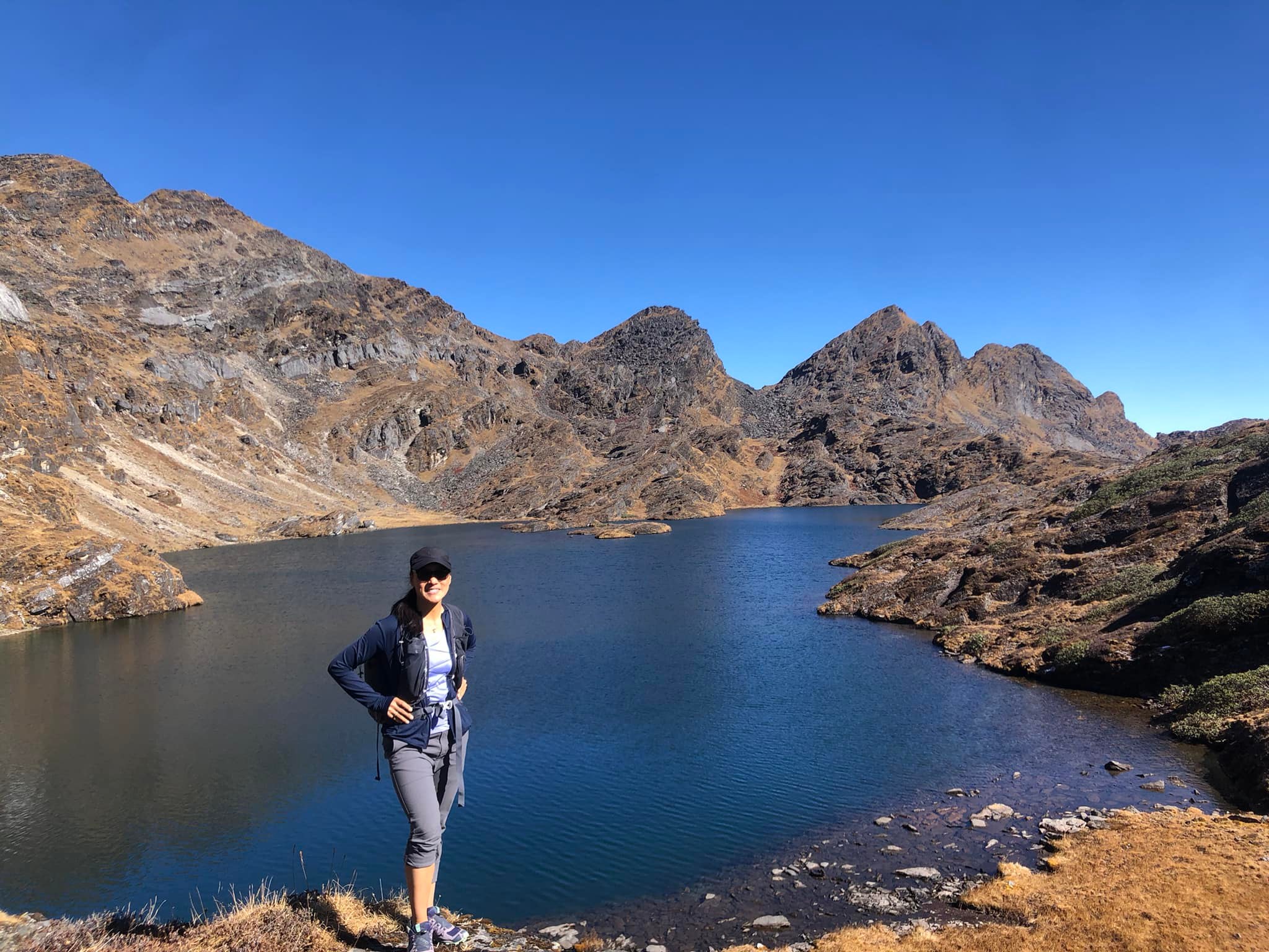 Tashi Chozom stands on the bank of a mountain lake, in which the deep blue sky is reflected,  surrounded by rugged cliffs.Tashi Chozom steht am Ufer eines Gebirgssees, in dem sich der tiefblaue Himmel spiegelt, um geben von schroffen Felsen.